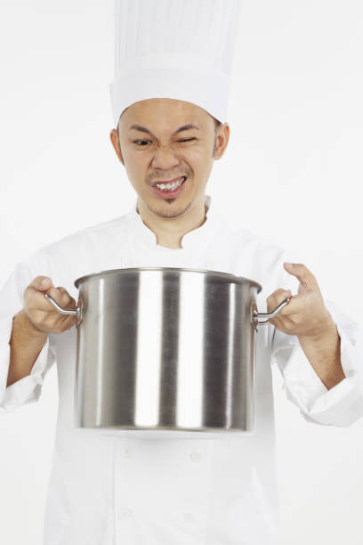 istock Worried Asian chef looking into stew pot 1267473079