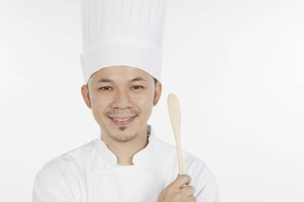 istock Asian chef holding wooden spoon 1267473122