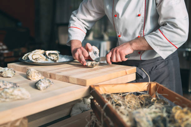 istock Opening the hollow and flat oysters. Chef opens oysters in the restaurant. 1267473582