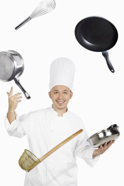 istock Asian chef juggling kitchen utensil 1267473620