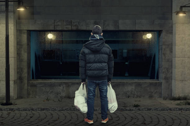 back of teen with white bags in the hand who standing in front of television showcase back of teen with white bags in the hand who standing in front of television showcase window shopping at night stock pictures, royalty-free photos & images