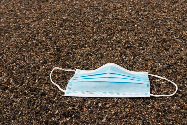 istock Used medical protective mask thrown on the floor. 1267474889