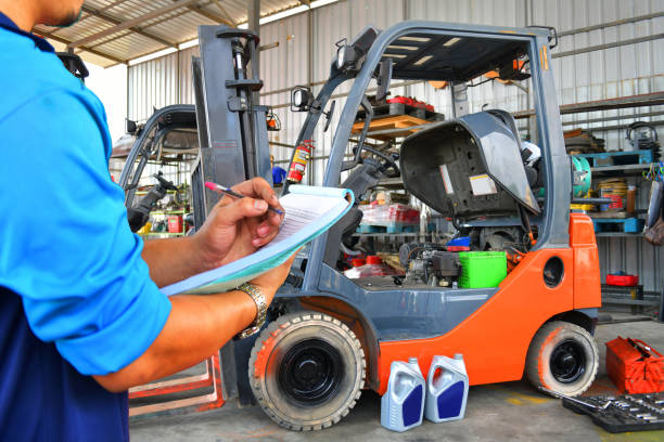 The mechanic is checking the quality and Maintenance Forklift stock photo
