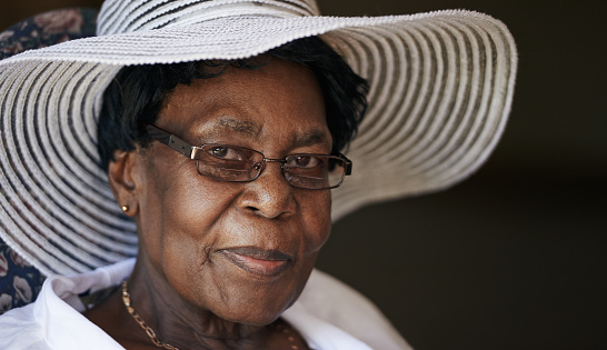Shot of a senior woman wearing glasses and a hat indoors