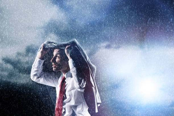 istock Businessman Caught in heavy Rain hiding under his jacket 1267484238