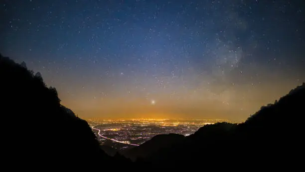 Photo of Starry night over a city from the mountains
