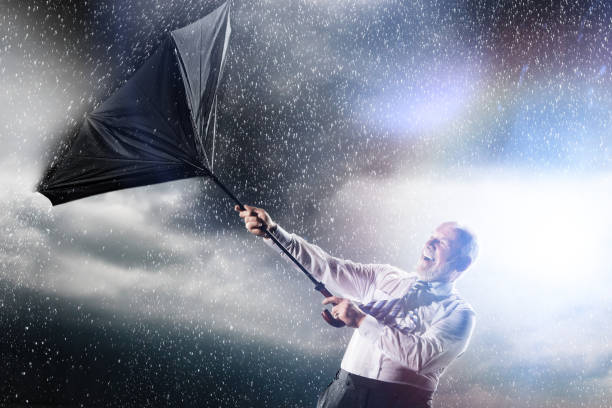 istock Businessman losing control of inside out umbrella 1267485008