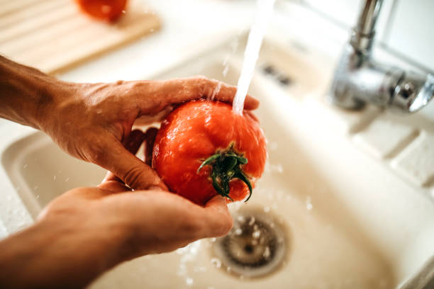 It has to be fresh and clean Women washing tomato in kitchen kitchen sink photos stock pictures, royalty-free photos & images