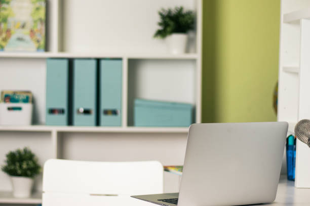 istock Office desk with laptop on table. Workspace with nobody. Copy space with blurry background 1267485429