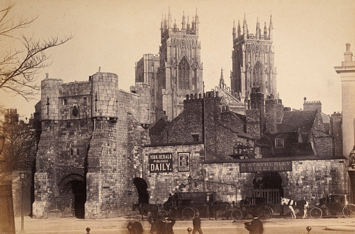 Antique photograph of Bootham Bar and York Minster, York, Yorkshire, England, 1880s, 19th Century, Advert for York Herald, R Weatherley Builder's yard, Horse and carriages, people walking in the street