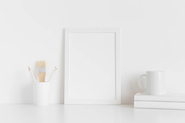 istock White frame mockup with workspace accessories on a white table. Portrait orientation. 1267489945