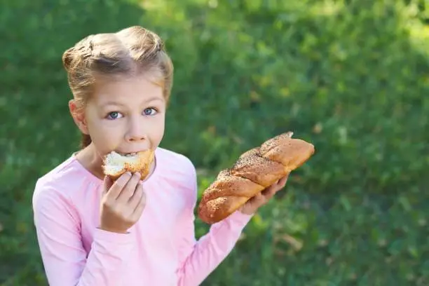 Portrait The girl is eating. Bun.