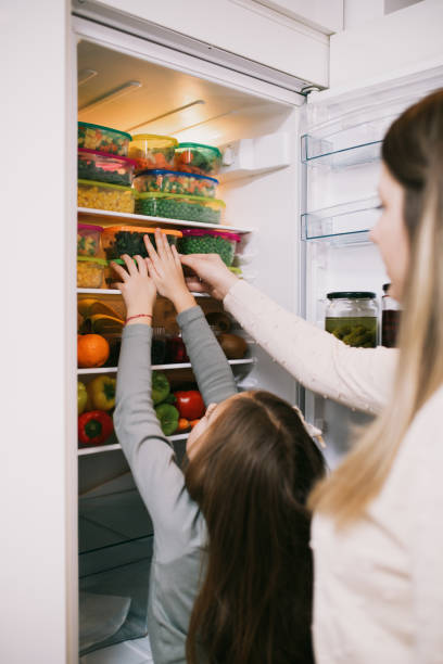 istock Mother and daughter preparing food 1267490953