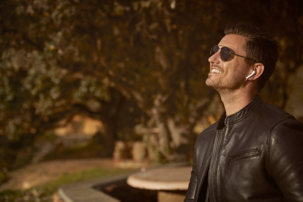 istock Handsome man using his smart phone and AirPods in public scenic park 1267492396