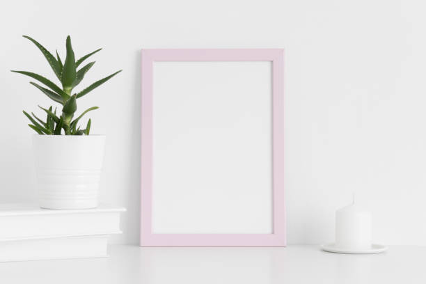 istock Pink frame mockup with workspace accessories and a aloe vera on a white table.Portrait orientation. 1267494547