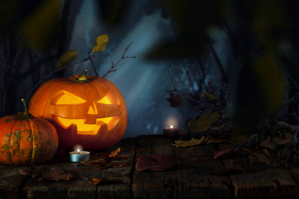 istock Jack O’ Lanterns Glowing At Moonlight In The Spooky Forest - Halloween Scene. 1267496889