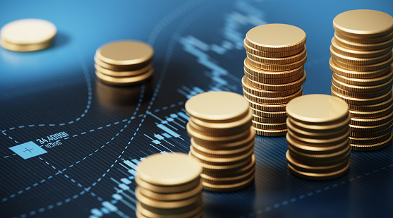 Coin stacks sitting on blue financial graph. Horizontal composition with selective focus and copy space. Finance concept.