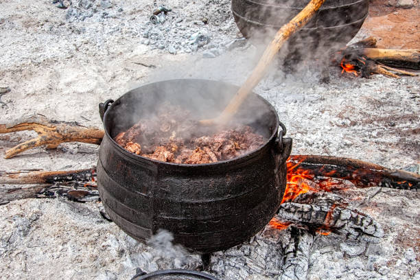 Outdoors kitchen in an African village frying fat meat for setswa in a large cast iron pot