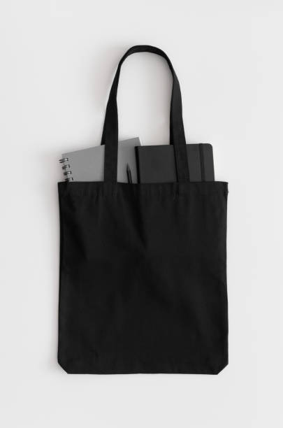 istock Black tote bag mockup with notebooks on a white table. 1267499165