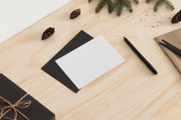 istock White card mockup with christmas decoration on a wooden table. 1267500736