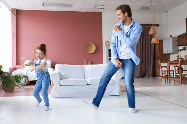istock Handsome young man dancing at home with his little cute daughter. 1267502965