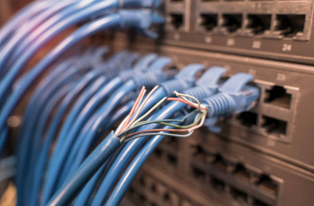 istock damaged stranded network cable is located on the background of the server room. Problem with communication 1267505296