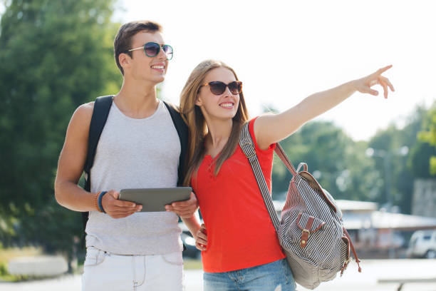 istock smiling couple with tablet pc and backpack in city 1267508366