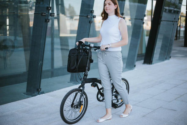 istock Businesswoman with her folding bike going to work 1267508841