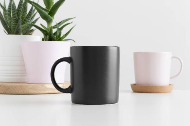 istock Black mug mockup with various types of succulent plants on a white table. 1267508986