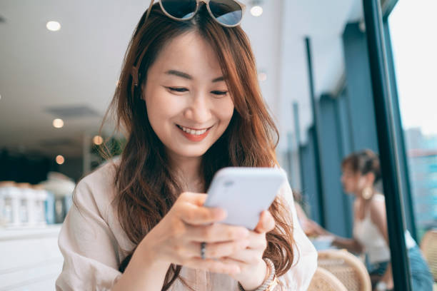 istock Young Woman Sitting In Cafe Using Smartphone 1267514463