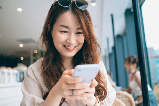 istock Young Woman Sitting In Cafe Using Smartphone 1267514464