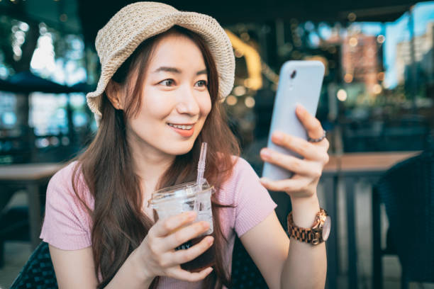 istock Young Woman Sitting In Cafe Using Smartphone 1267514471