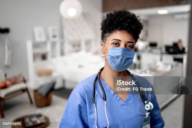 Portrait Of A Young Nursedoctor On A House Call With Face Mask Stock Photo - Download Image Now