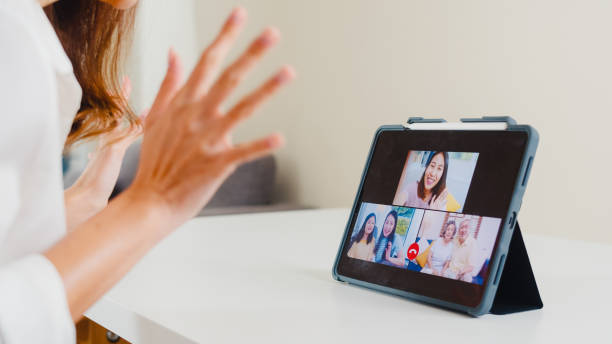 young asian business female using tablet video call talking with family while working from home at living room. - father digital tablet asian ethnicity daughter imagens e fotografias de stock