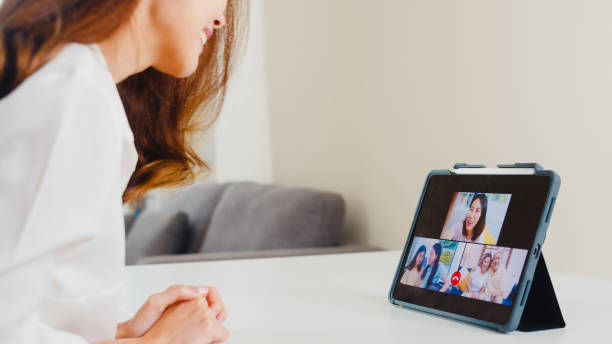 young asian business female using tablet video call talking with family while working from home at living room. - father digital tablet asian ethnicity daughter imagens e fotografias de stock