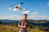 Drone remote control. Man operating copter controller in mountains. Aerial video shooting of summer Carpathins