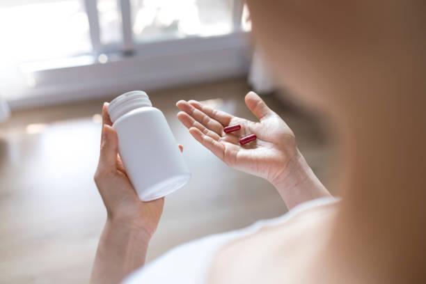 istock Woman taking vitamins and supplements 1267521714