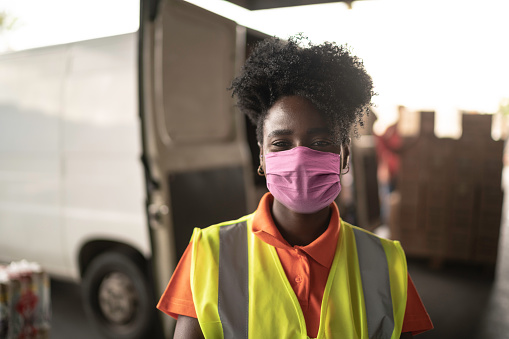 Retrato de mujer joven africana en el almacén con máscara facial photo
