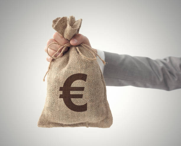 money bag with euro sign european union currency business man holding up - european union coin european union currency coin isolated objects imagens e fotografias de stock