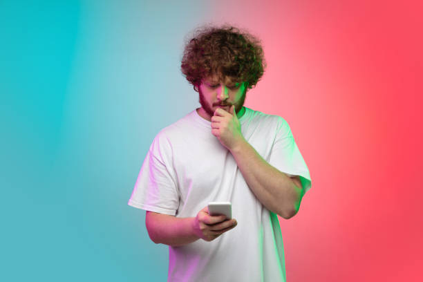 istock Caucasian young man's portrait on gradient studio background in neon 1267527315
