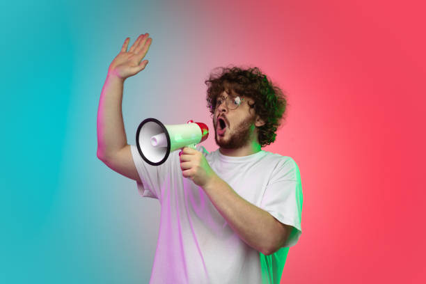 istock Caucasian young man's portrait on gradient studio background in neon 1267527325