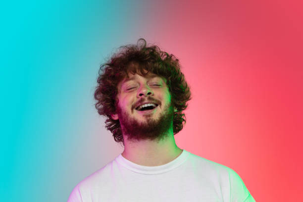 istock Caucasian young man's portrait on gradient studio background in neon 1267527334