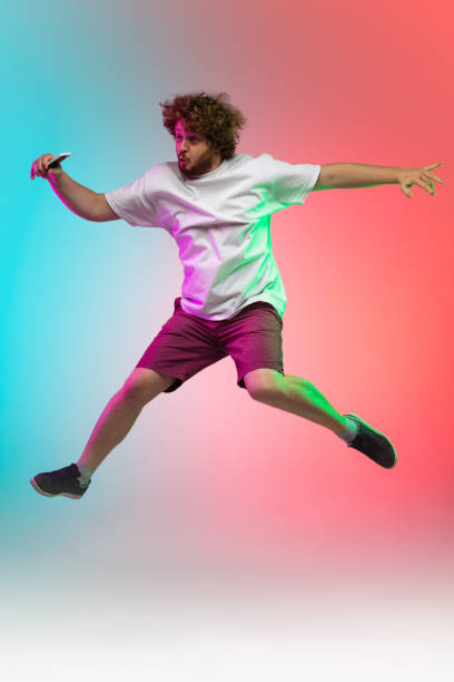 istock Caucasian young man's portrait on gradient studio background in neon 1267527344