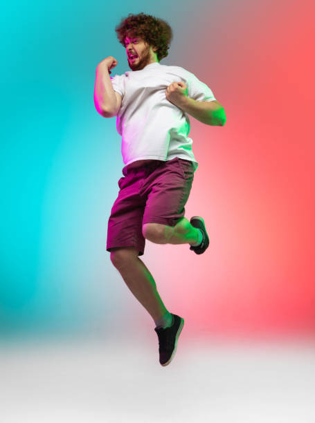 istock Caucasian young man's portrait on gradient studio background in neon 1267527345