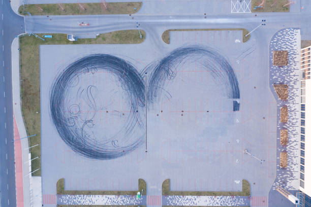 istock Car drift skid marks on empty parking lot 1267527363