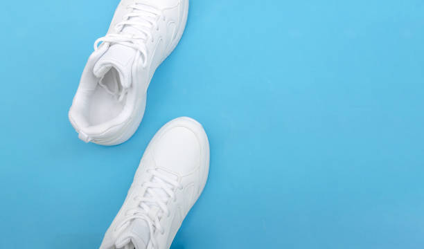 istock White sneakers on a blue background copy space, top view 1267528548