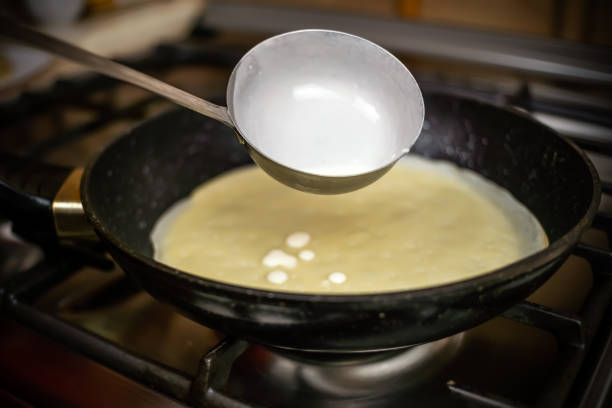 istock Pancake batter is poured into the pan from a bucket close up 1267528721