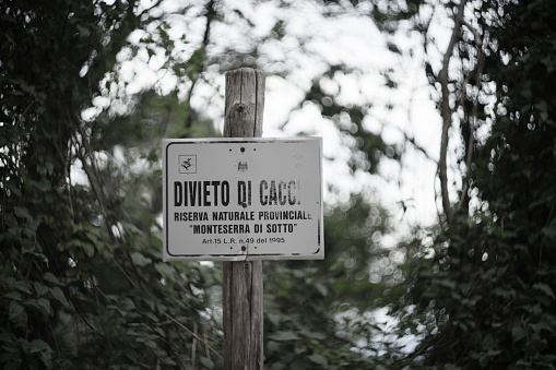 Calci, Italy - August 17, 2010: an old discoloured sign says that hunting is forbidden here on Mt Serra, a mountain in Tuscany. Italian language