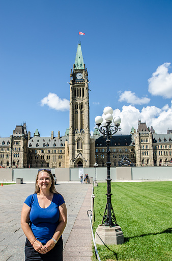 Proud Canadian Woman in front of Parliament of Canada during summer day