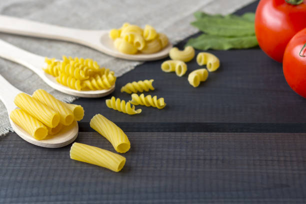 istock Uncooked pasta in a wooden spoon 1267533860